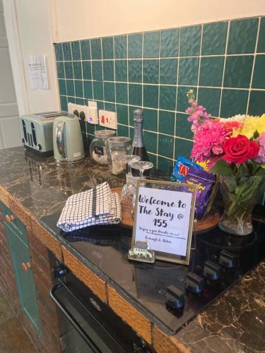 a kitchen counter with a sign that says welcome to the stay at The Stay @ 155 