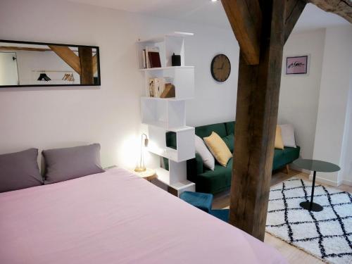 1 dormitorio con 1 cama y 1 sofá verde en Le nid douillet d'Honfleur, en Équemauville