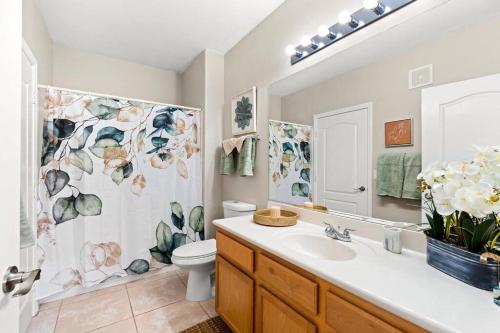 uma casa de banho com um lavatório, um WC e um espelho. em Live in Style: Luxury Condo em Henderson