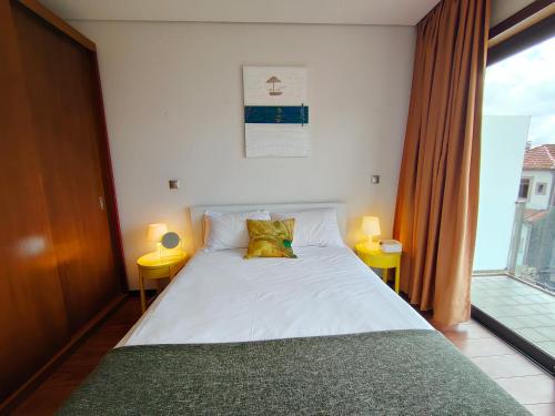um quarto com uma cama com 2 candeeiros e uma janela em Duque da Terceira apartment no Porto