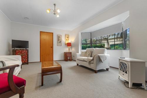 a living room with a couch and a chair at Central Comforts - Mount Eden Holiday Home in Auckland