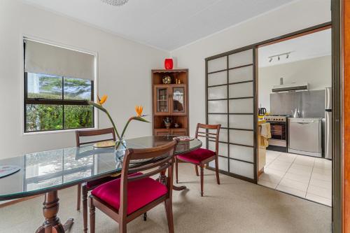 a dining room with a glass table and chairs at Central Comforts - Mount Eden Holiday Home in Auckland