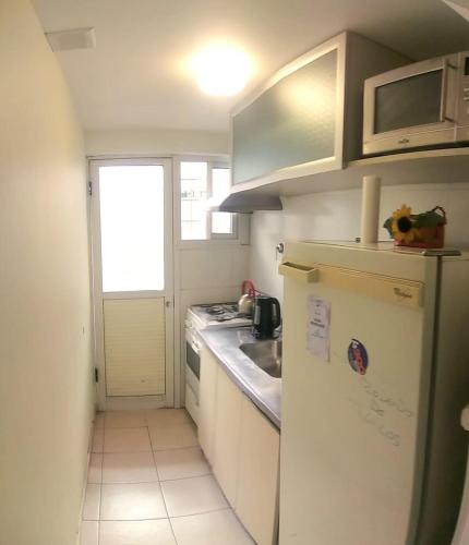 una pequeña cocina con nevera y fregadero en Departamento MENDOZA QUINTA en Mendoza