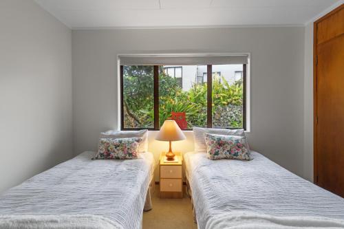 two twin beds in a room with a window at Central Comforts - Mount Eden Holiday Home in Auckland