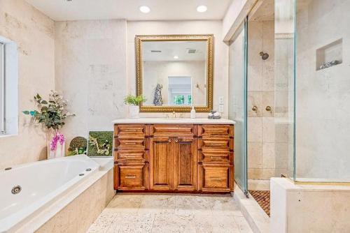 een badkamer met een bad, een wastafel en een spiegel bij Coconut Grove, Miami FL in Miami