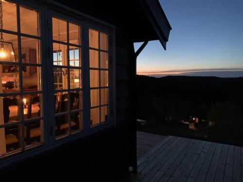 a sunset seen through the windows of a house at Middagslia - cabin at Skrim with amazing view in Omholt