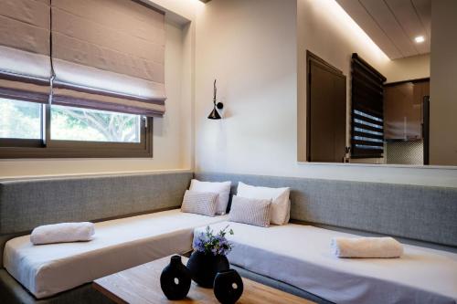 two beds sitting in a room with a window at Iasmos Luxury Apartment in Heraklio