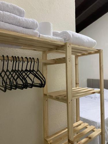 una estantería de madera con toallas junto a una cama en Hospedagens Express II, en Chapada dos Guimarães