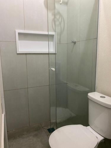 La salle de bains est pourvue de toilettes et d'une douche en verre. dans l'établissement Hospedagens Express II, à Chapada dos Guimarães