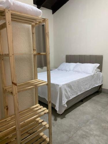 a bedroom with a bunk bed with white sheets at Hospedagens Express II in Chapada dos Guimarães
