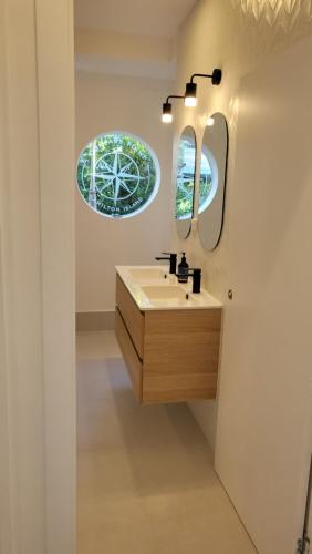 uma casa de banho com um lavatório e um espelho em Luxury Couples Retreat Hamilton Island and golf buggy - Renovated August 2023 em Hamilton Island