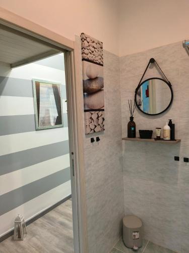 a bathroom with a shower door and a mirror at Relax room Apartment in Rome