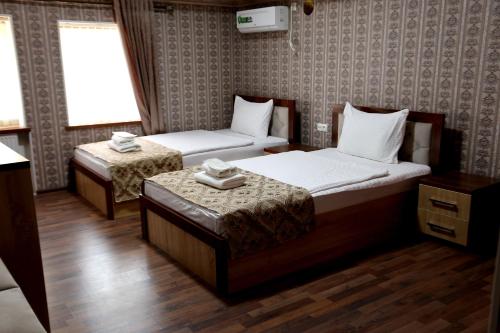 Hotel Plaza 777 في سمرقند: غرفة فندقية بسريرين ونافذة