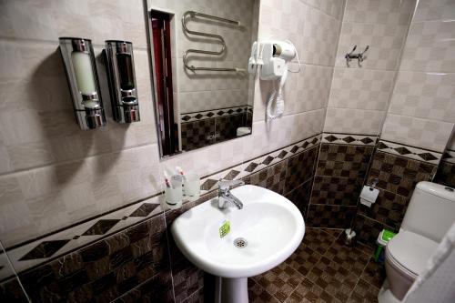 Hotel Plaza 777 في سمرقند: حمام مع حوض ومرحاض