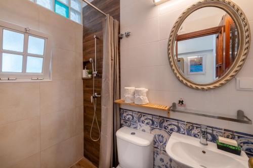 La salle de bains est pourvue de toilettes, d'un lavabo et d'un miroir. dans l'établissement Casa Cecilia Apartment Algarve, à Alte