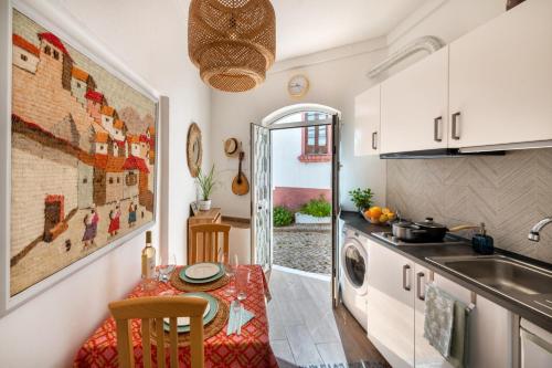 a kitchen with a table and a sink and a stove at Casa Cecilia Apartment Algarve in Alte
