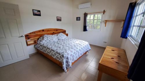 a bedroom with a bed and a table and a window at Casita del Arco El Cedral Cozumel in Cozumel
