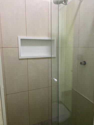 W łazience znajduje się prysznic ze szklanymi drzwiami. w obiekcie Hospedagens Express I w mieście Chapada dos Guimarães