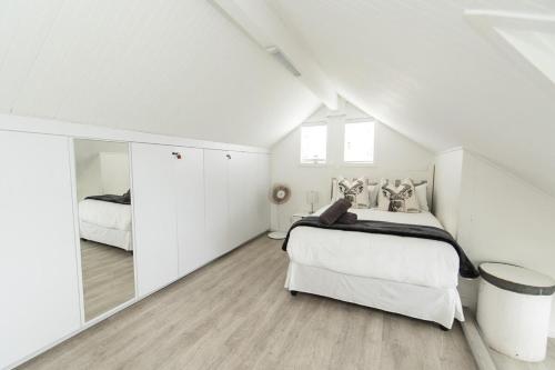 ein weißes Schlafzimmer mit 2 Betten im Dachgeschoss in der Unterkunft Dolphins View Luxury Apartment in Port Elizabeth