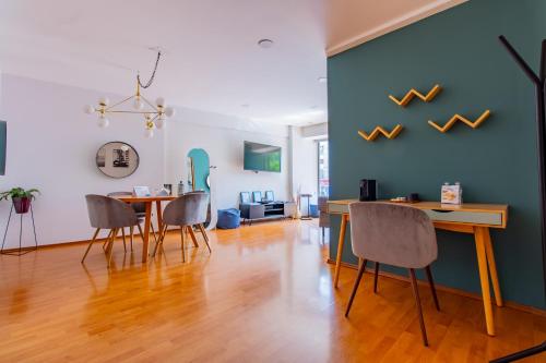 a dining room with a blue wall and a table and chairs at Capitalia Anzures Polanco in Mexico City