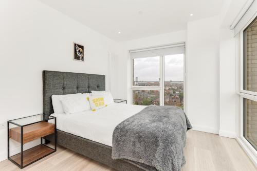 Un dormitorio blanco con una cama grande y una ventana en Bloom of Luxury en Londres