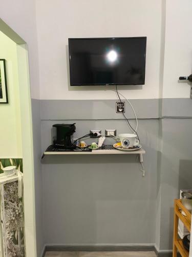 a flat screen tv on a wall with a shelf at Relax room Apartment in Rome