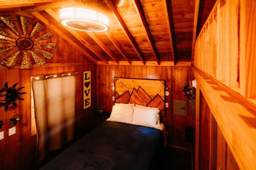 1 dormitorio pequeño con 1 cama en una habitación de madera en La Junta Colorado Cabins, en La Junta