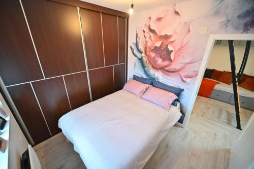 a small room with a flower painting on the wall at Apartmani Dimitrije Jahorina in Jahorina