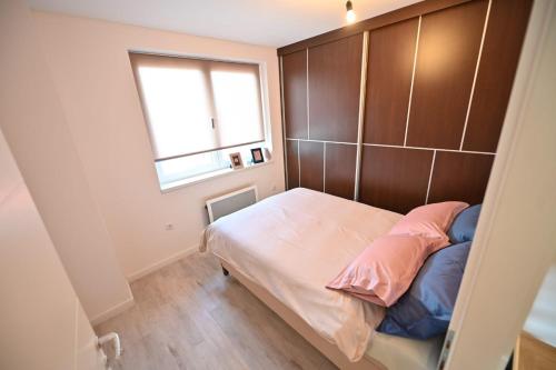 a small bedroom with a bed with a wooden headboard at Apartmani Dimitrije Jahorina in Jahorina