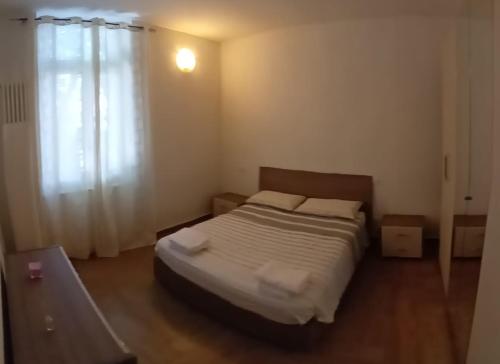 1 dormitorio con 1 cama con sábanas blancas y ventana en Casa Bianca en Tortona