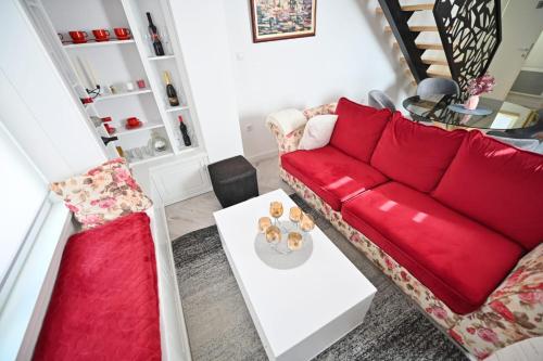 a living room with a red couch and a table at Apartmani Dimitrije Jahorina in Jahorina