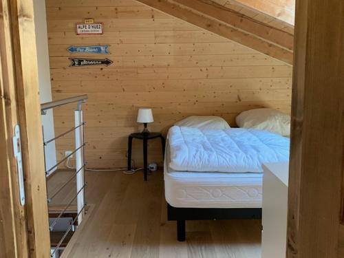ein kleines Zimmer mit einem Bett in einer Holzwand in der Unterkunft Appartement Huez, 2 pièces, 5 personnes - FR-1-405-217 in Huez