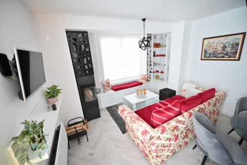 a living room with a red couch and a window at Apartmani Dimitrije Jahorina in Jahorina