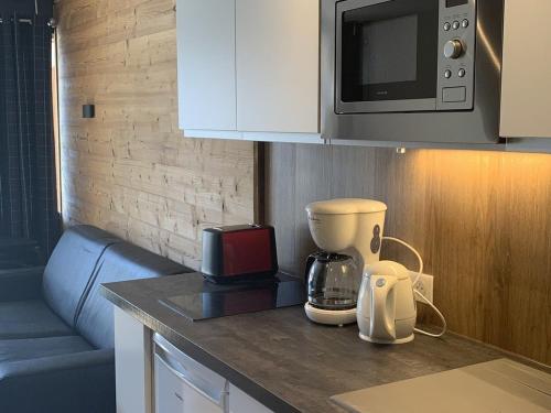 - un comptoir de cuisine avec une cafetière et un four micro-ondes dans l'établissement Studio pour 4 à L'Alpe d'Huez - Proche pistes et commerces, terrasse sud, TV, casier à skis - FR-1-405-218, à Huez