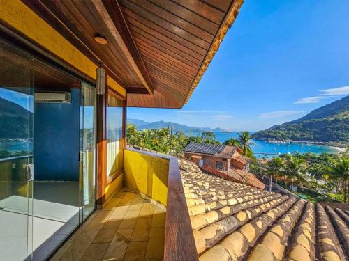 uma casa com uma varanda com vista para o oceano em Casa amarela portogalo Angra dos Reis em Angra dos Reis