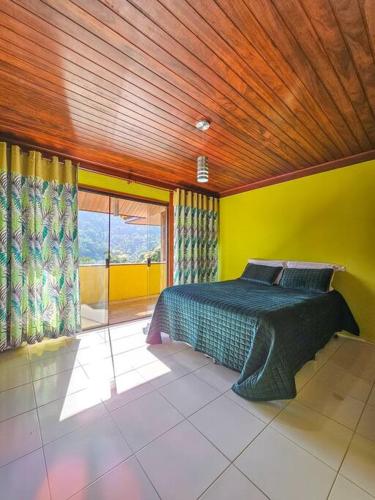 um quarto com uma cama e um tecto em madeira em Casa amarela portogalo Angra dos Reis em Angra dos Reis