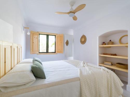 a white bedroom with a bed and a ceiling fan at Apartamento Primera Línea de Playa in San Bartolomé de Tirajana