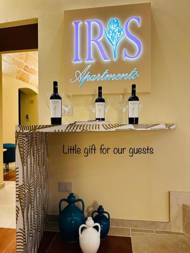 a sign with bottles of wine on a shelf at Iris Apartments in Monopoli