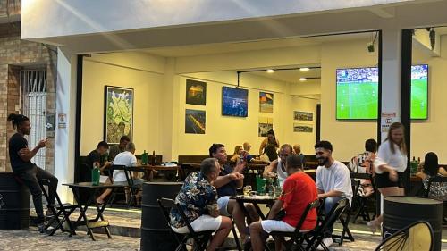 eine Gruppe von Personen, die in einem Restaurant an Tischen sitzen in der Unterkunft Gadhega's Hotel in Salvador