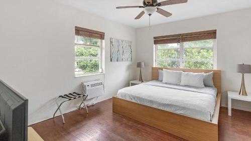 a white bedroom with a bed and two windows at Brickell Tree Apartment Beach 10min Location Shops in Miami