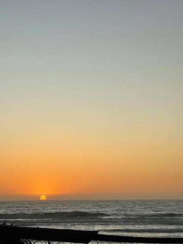 a sunset over the ocean with the sun in the distance at Cabaña Maitencillo frente al mar in Maitencillo