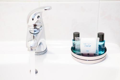 a bathroom with a sink and a faucet at Stork Hostel in Olhão