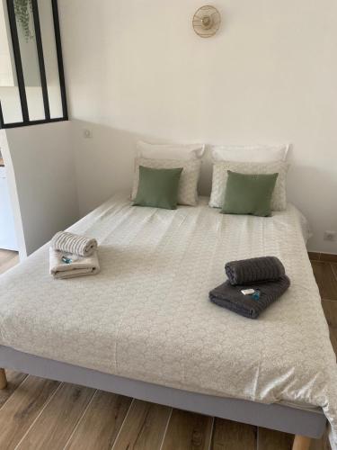 a bed with two towels and pillows on it at Mistral gagnant - parking privé in Cassis