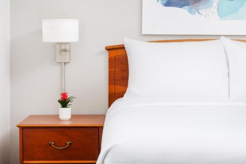 a bedroom with a bed and a nightstand with a flower on it at TownePlace Suites Philadelphia Horsham in Horsham