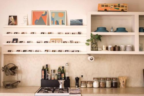 a kitchen with white shelves and a counter with bottles at Authentic Loft Retreat Steps from Beach & Culture in San José del Cabo