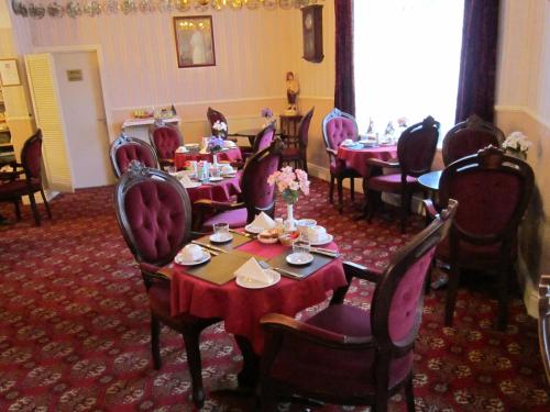 a dining room with tables and chairs with flowers on them at Sussex Hotel in Blackpool