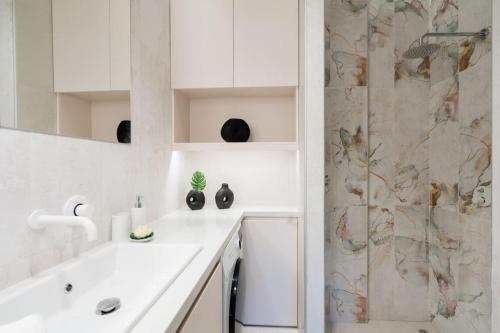 biała łazienka z prysznicem i umywalką w obiekcie Euphoria Luxury Apartment w Heraklionie