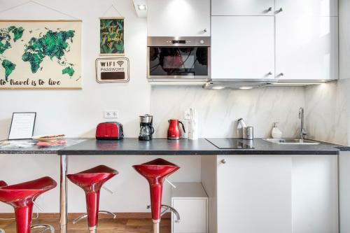 a kitchen with red stools in front of a counter at Mehdi residence 3 in Budapest
