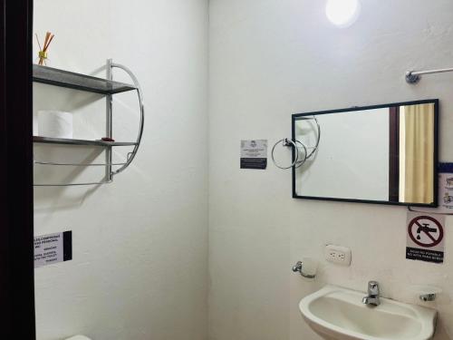 a bathroom with a mirror and a sink at Zuruma Hotel in Leticia