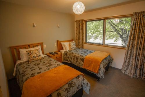 sypialnia z 2 łóżkami i oknem w obiekcie Woodland Glen Lodge B&B w mieście Hokitika